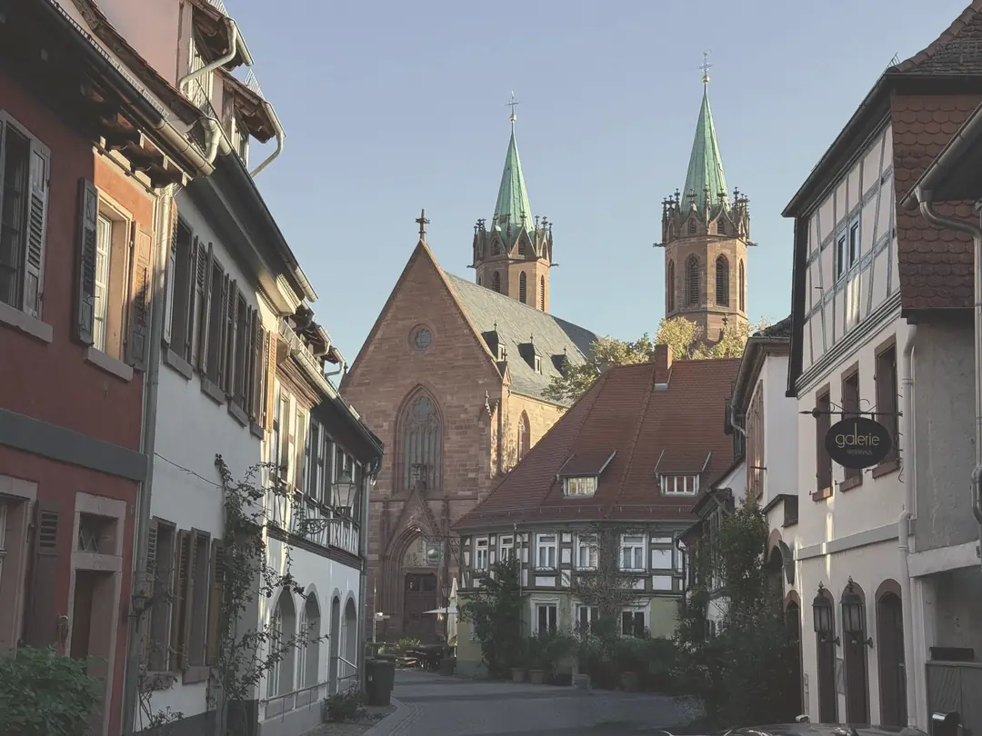 Gasse in der Ladenburger Altstadt, an ihrem Ende die Kirche St. Gallus mit ihren zwei Türmen